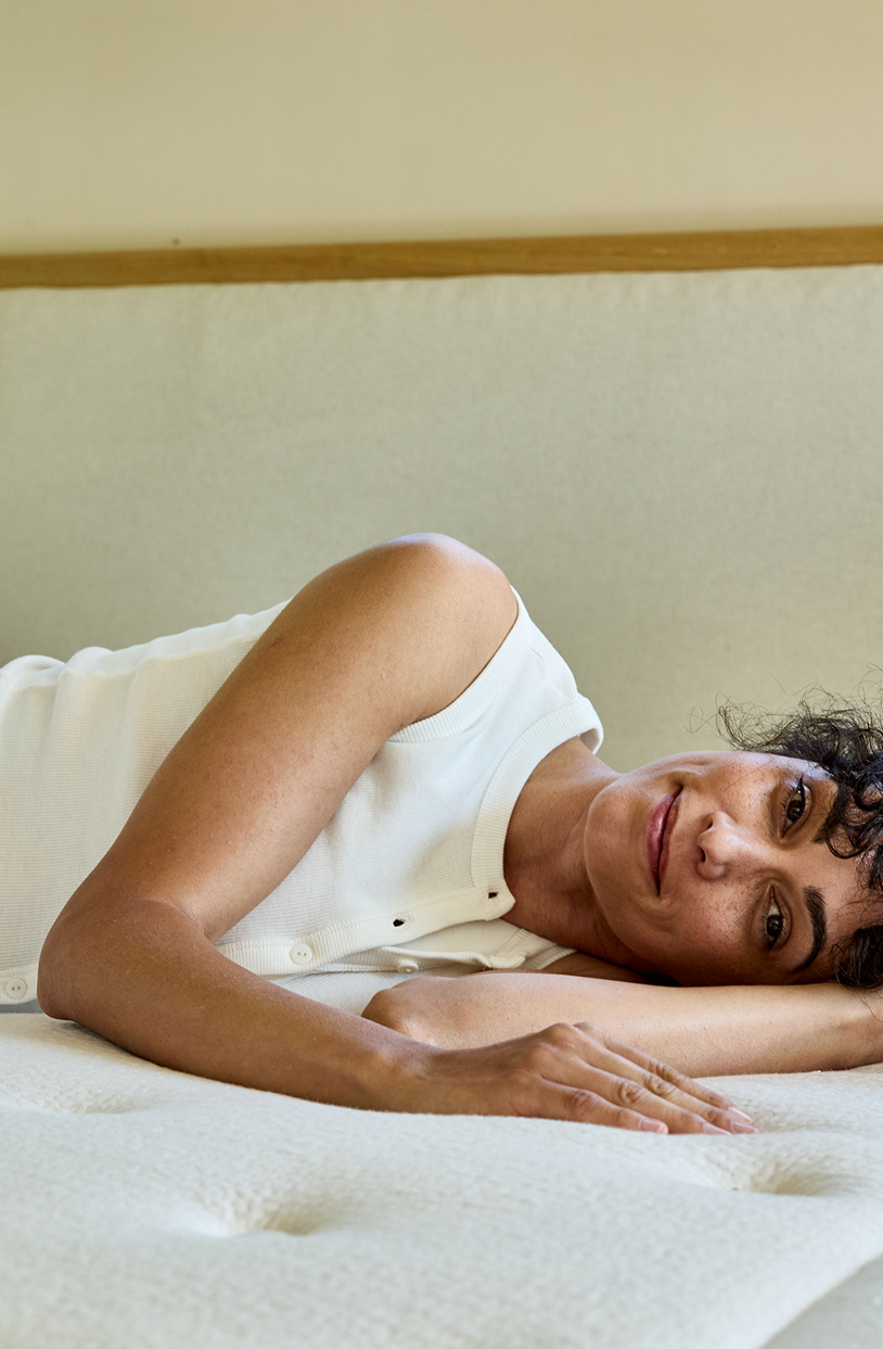 Donna sdraiata su un materasso in lattice naturale Kipli, a dimostrazione del comfort e del sostegno offerti da un sistema letto ecologico.
