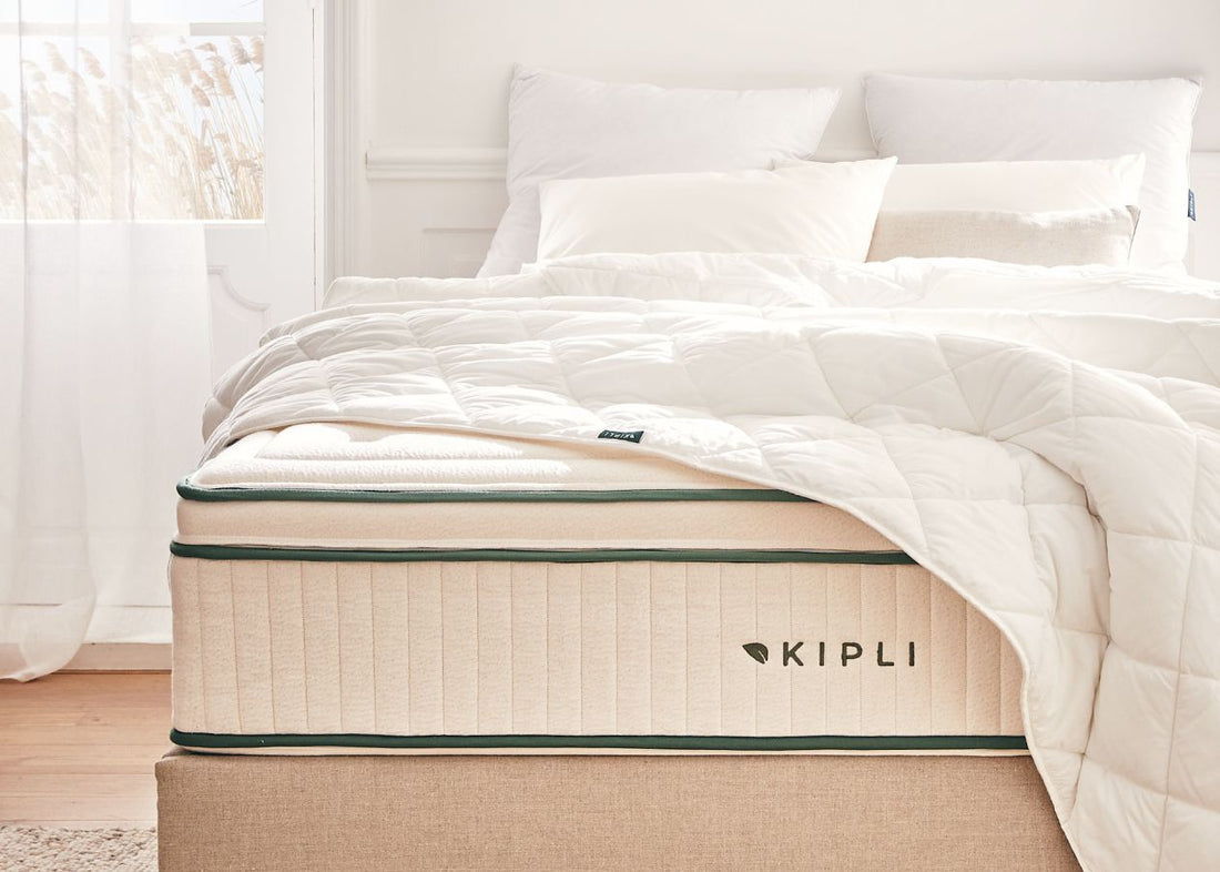 Eine Kipli-Matratze aus Naturlatex mit weißer Bettdecke und weißen Kissen – ein Beispiel für gesunde und nachhaltige Bettwäsche in einem hellen Schlafzimmer.