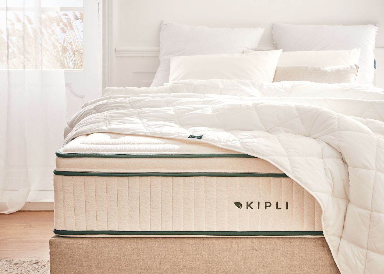 Eine Kipli-Matratze aus Naturlatex mit weißer Bettdecke und weißen Kissen – ein Beispiel für gesunde und nachhaltige Bettwäsche in einem hellen Schlafzimmer.